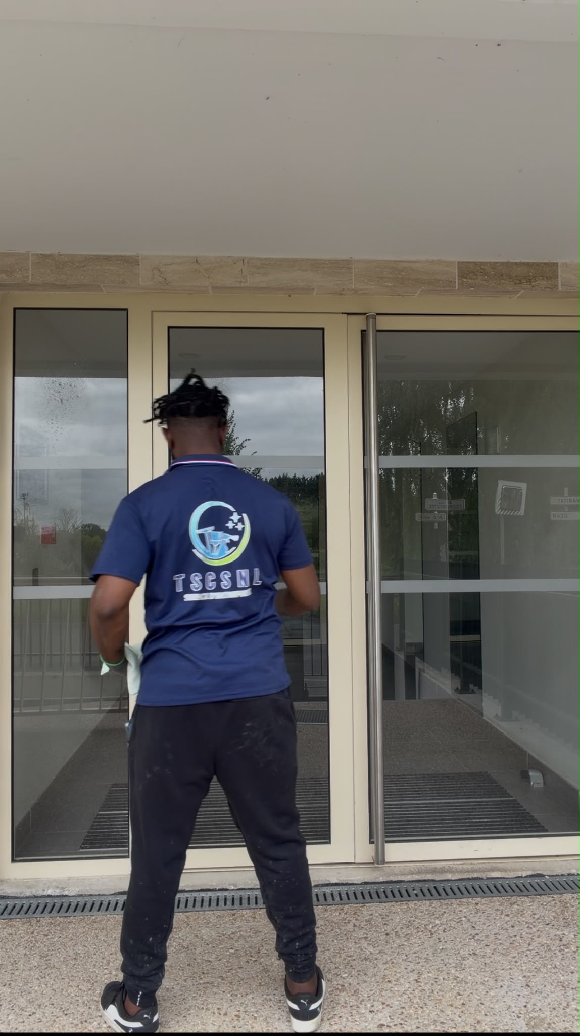 Technicien TSCSNL nettoyant les vitres d'un bâtiment